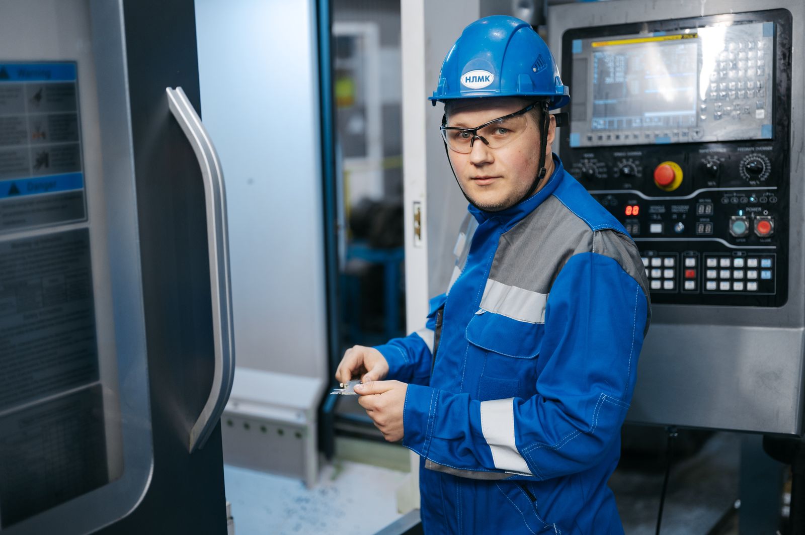 Ingeniero industrial con equipo de protección operando una máquina CNC